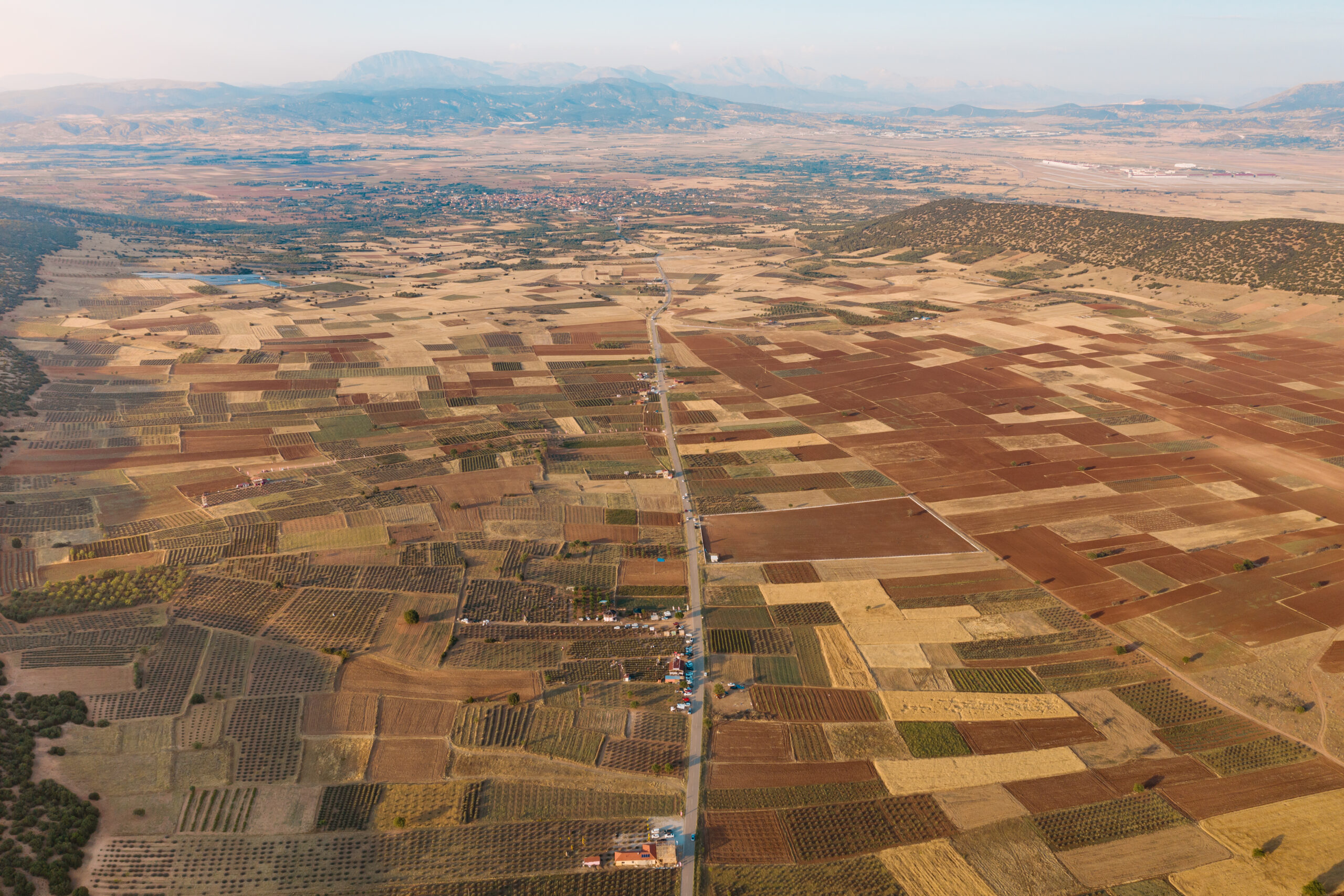 Aerial view of meadows and cultivated fields with pathway. Birds view. Arable land.